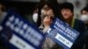 People queue to see the Tokyo 2020 Olympic flame on display outside the railway station in Tono, Iwate prefecture on March 22, 2020. - The flame arrived in Japan to a scaled-down welcoming ceremony on March 20 as doubts grew over whether the 2020…