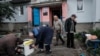 Residents use a generator to charge their mobile phones and flashlights in front of their apartment building in Kupiansk, Kharkiv region, Sept. 24, 2022, amid Russia's military invasion on Ukraine.