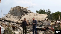 Watu wakitizama eneo la shambulizi la anga la Israel lililolenga nyumba moja katika kijiji cha Jibshit kusini mwa Lebanon, Februari 27, 2024. Picha ya AFP