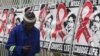 A man makes a call on a mobile phone as he passes past a World AIDS Day banners on the perimeter of an office building in Sandton, Johannesburg, South Africa, Dec. 1, 2014. 