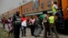 FILE - A policeman stands guard as people try to board a train on the Lagos to Kano route in Lagos, Nigeria. 