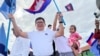 FILE - Vice President of Candlelight Party, Son Chhay, waves flags during a campaign rally for the upcoming local elections on June 5, in Phnom Penh, Cambodia May 21, 2022. 