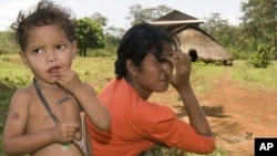 An ethnic minority Cambodian boy, left, stands next to his mother at a village in Mondul Kiri province some 265 kilometers (165 miles) northeast Phnom Penh, file photo.