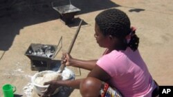 Jovem prepara funje de bombo nas tendas dos refugiados em Malanje