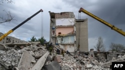 Los rescatistas despejan la escena después de que un edificio fuera parcialmente destruido como resultado del impacto de un misil ruso en Chasiv Yar, distrito de Bakhmut, este de Ucrania, el 10 de julio de 2022.