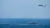 FILE - A U.S. Navy Seahawk helicopter flies over a stateless dhow later found to be carrying a hidden arms shipment in the Arabian Sea, May 6, 2021. 