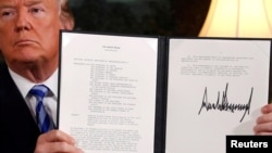 도널드 트럼프 미국 대통령이 지난 5월 백악관 외교접견실에서 이란핵합의(JCPOA) 탈퇴에 공식 서명한 후 이를 들어 보이고 있다. 