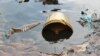 FILE - Crude oil from a Shell pipeline spill accumulates along a riverbank in the Oloma community in the Niger Delta, Nov. 27, 2014.
