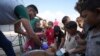 FILE - Displaced Palestinian children queue for food in a camp in Deir al-Balah, Gaza Strip, Oct. 18, 2024. 