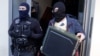 FILE - German special police leave a house in Berlin Nov. 15, 2016. German police launched dawn raids on mosques, apartments and offices in 10 German states, and the government banned a group it accused of trying to recruit fighters for Islamic State, the interior ministry said.