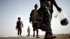 FILE - Ethiopian migrants walk on the side of a highway leading to the western Yemeni town of Haradh, on the border with Saudi Arabia.