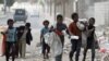 Children walk as they collect empty plastic bottles in a street in Sanaa, Yemen, Nov. 21, 2019. 
