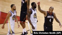 PJ Tucker des Houston Rockets, à droite, Draymond Green des Golden Warriors, au centre, et son coéquipier Stephen Curry, à gauche, Houston, le 24 mai 2018. 