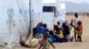 FILE - Nigerian refugees sit by a UNHCR tent in the refugee camp of Minawao, on the border of Nigeria at the extreme north of Cameroon, March 29, 2014. 