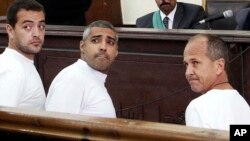 Le producteur Baher Mohamed, à gauche, le chef de bureau Mohammed Fahmy, au centre, et le corrrespondant Peter Greste lors d'une comparution au Caire (Archives)