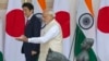 Indian Prime Minister Narendra Modi, right, shows the way to his Japanese counterpart Shinzo Abe as they arrive for their meeting, in New Delhi, India, Dec. 12, 2015. 