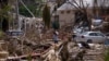 People walk next to rubble and damaged trees in the aftermath of Hurricane Otis, in Acapulco, Mexico, Oct. 29, 2023.