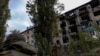 FILE - A police officer walks near a damaged residential building in the town of Avdiivka, Donetsk region, Ukraine, Oct. 17, 2023. A U.S. official said some Russian soldiers found dead in recent fighting near the town were killed by order of their own leaders. 