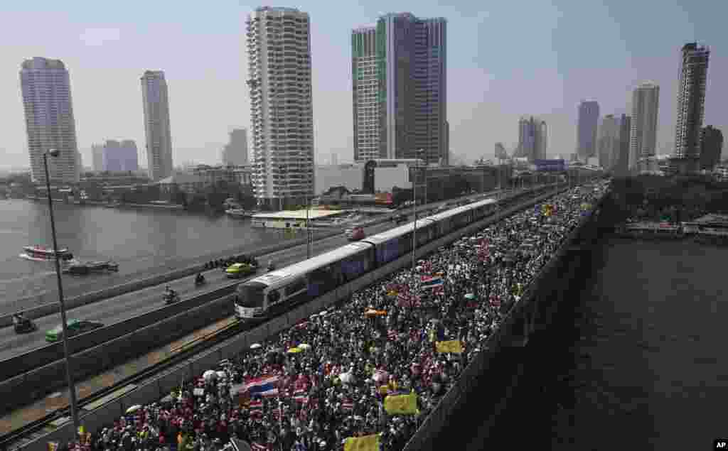 Anti-government protesters march cross Takin Bridge during a rally in Bangkok, Dec. 22, 2013.