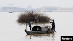 FILE- Locals manoeuvre their small vessels along the Mekong river in Phnom Penh, Cambodia, November 7, 2012. 