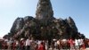 In this Sunday, Dec. 31, 2017, photo, tourists line up for stepping up Angkor Wat temple outside Siem Reap, Cambodia. Tourists celebrated New Year at Angkor Wat temple where is Cambodia's main tourist destination. The temples, built between the 9th and 15th centuries. (AP Photo/Heng Sinith)