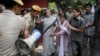 India's opposition Congress party president Sonia Gandhi, second left, is escorted by her security personnel as she leads a march against the ruling Bharatiya Janata Party (BJP) government in New Delhi, India on May 6, 2016.