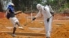 A man is sprayed with disinfectant after he celebrated the memory of a loved one who died due to the Ebola virus at a newly build grave yard for Ebola virus victims in Monrovia, Liberia, Wednesday, March 11, 2015. Liberians held a church service Wednesday