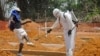 FILE - A man is sprayed with disinfectant at a newly built graveyard for Ebola victims in Monrovia, Liberia, March 2015.