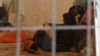 FILE - In this Saturday, Sept. 9, 2017 image made from video, a woman and a small child lie on the floor of a tent in a camp for displaced people on the outskirts of Mosul, Iraq. Over 1,300 women and children, all foreign nationals and relatives of Islamic Stat