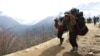 FILE - Nepalese porters carry heavy loads for climbers on their way to Everest Base Camp at Kyangjuma, Nepal in this April 7, 2015 photo.. 