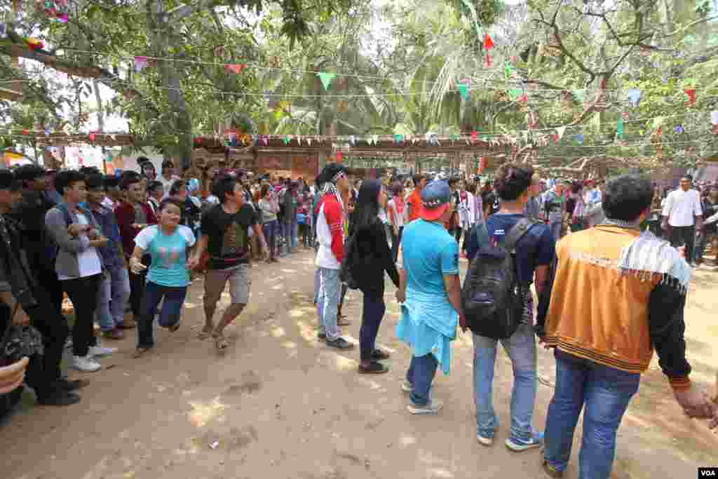 យុវជនខ្មែរមួយក្រុមលេងល្បែង«ពង្រត់កូនក្រមុំគេ»ក្នុងពិធីមួយដើម្បីប្រារព្ធចូលឆ្នាំខ្មែរនៅវត្តជ្រោយអំពិលខ័ណ្ឌច្បារអំពៅរាជធានីភ្នំពេញកាលពីថ្ងៃសៅរ៍ទី០៩ខែមេសានេះ។ ប្រជាជនខ្មែរប្រារព្ធពិធីបុណ្យចូលឆ្នាំខ្មែរចាប់ពី ថ្ងៃទី ១៣ដល់ទី១៦ខែមេសាឆ្នាំ២០១៦នេះ នៃឆ្នាំវក សត្វស្វា។ (ឡេង ឡែន/VOA)