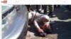 Chhean Pisith, a border police officer, was recorded collapsing in front of a car owned by Din Puthy, a local Cambodia National Rescue Party official in Poipet (Courtesy of YouTube.com). 
