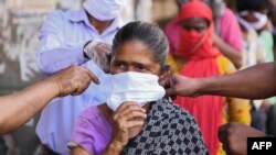 Watu wa Dayosisi ya Kanisa la Amritsar Kaskazini mwa India wakigawa maski kwa wananchi wakati serikali ya India ilipotangaza amri ya kutotoka nje kudhibiti janga la corona Aprili 15, 2020. (Photo by NARINDER…