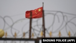 資料照片：中國新疆喀什南部陽伊薩爾的一個住宅區內，鐵絲網後方飄揚著中國國旗。(2019年6月4日)