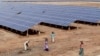 FILE - Indian laborers work near solar panels at the Gujarat Solar Park at Charanka in Patan district, about 250 kilometers (155 miles) from Ahmadabad, India.