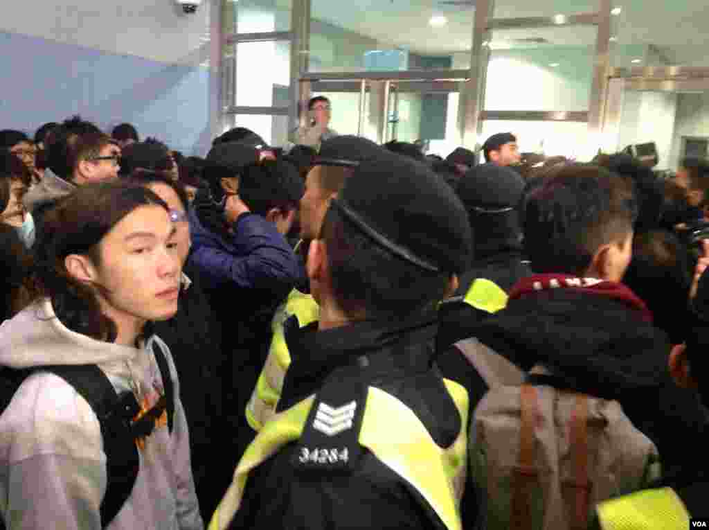 香港警方以有人報案摔倒受傷需要調查為由進入校委會早前開會的港大校園，受到在場抗議的學生和市民的抗議和圍堵，現場一片要求警察離開校園的呼喊聲。