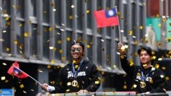 2024年11月26日，在台北，台灣棒球隊隊長陳傑憲(右)和球員林家正在慶祝球隊贏得2024WBSC十二強棒球錦標賽冠軍的遊行中向人群揮手致意。 （法新社）