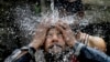 A Pakistani man cools himself off under a water supply to beat the heat during the holy fasting month of Ramadan, in Islamabad, Pakistan, June 7, 2016. 