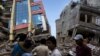 People walk past a collapsed building after a fresh 7.3 earthquake struck, in Kathmandu, Nepal, May 12, 2015.