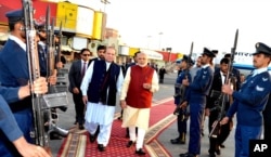 FILE - In this photo released by Press Information Department, India's Prime Minister Narendra Modi, right, reviews guard of honor with his Pakistani counterpart, Nawaz Sharif, in Lahore, Pakistan, Dec. 25, 2015.