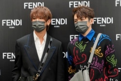 FILE - Keung To, left, and Ian Chan, members of the Cantopop band Mirror, pose for a photo during a promotional event of a luxury store in Hong Kong, July 22, 2021.