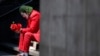 David Vázquez, un artista callejero disfrazado de Joker, espera con la esperanza de que lleguen los peatones que pagarán por tomarse fotos con él en la Ciudad de México, el lunes 23 de marzo de 2020. 