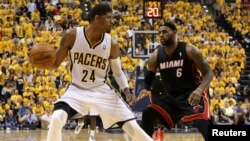 Le joueur-vedette des Indiana Pacers Paul George (24), à gauche, tente un drible face à LeBron James (6) de Miami Heat lors d'un match de basketball de la NBA, le 28 mars 2014.