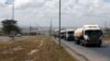 FILE - Trucks drive along the main road from the port city of Mombasa in the outskirts of Kenya's capital, Nairobi, March 4, 2016.