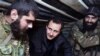 FILE - Syrian President Bashar al-Assad, center, speaks with Syrian troops during his visit to the front line in the eastern Damascus district of Jobar, Dec. 31, 2014.
