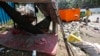 FILE PHOTO - A young girl sleeps in a hammock as her mother clears garbage, along a street in central Phnom Penh, Cambodia, October 3, 2014. REUTERS/Samrang Pring 
