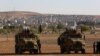 FILE - Turkish soldiers take up position a few hundreds meters from the border with Syria not far from the Syrian Kurd city of Kobani, from their vantage point near Suruc, Turkey, Oct. 4, 2014.