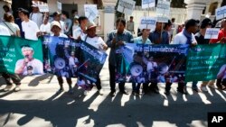 Protesters hold banner printed with detained activist Von Pov in front of the Appeals Court during a rally in Phnom Penh, file photo. 