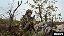 A Ukrainian serviceman inspects a RPG-7 shell at a former Russian position outside the village of Robotyne, amid Russia's attack on Ukraine, near a front line in Zaporizhzhia region, Ukraine Nov. 4, 2023.