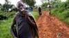 FILE - Ombeni Balihiamwabo,17, stands with his rifle outside a military post in Nyangonbe, Democratic Republic of Congo.